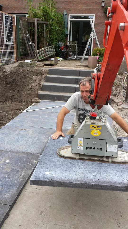 Een grote traptrede wordt met een vacuümheffer op zijn plaats gelegd